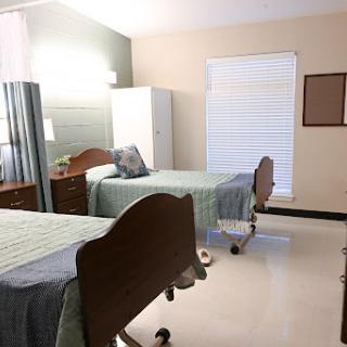 A patient room in a healthcare facility featuring two beds, providing a clean and organized space.