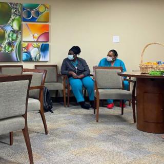 Two nurses seated in a hospital waiting area.