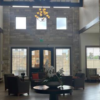 A spacious lobby with comfortable seating and a chandelier.