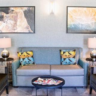 A stylish living room with a sofa, decorative cushions, and artwork on the walls.