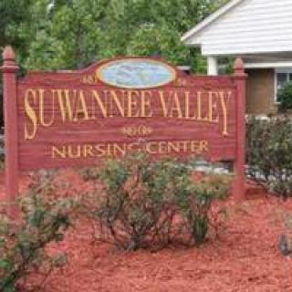 A sign for Suwannee Valley Nursing Center surrounded by landscaping with red mulch.