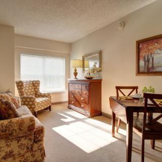 A cozy living room with warm sunlight streaming through the window, featuring elegant furniture and decor.