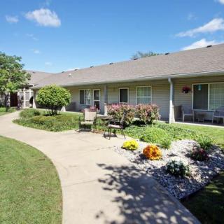 A well-maintained garden with a paved pathway in front of a residential building.