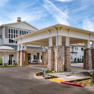 A modern building entrance with stone columns and a covered driveway.