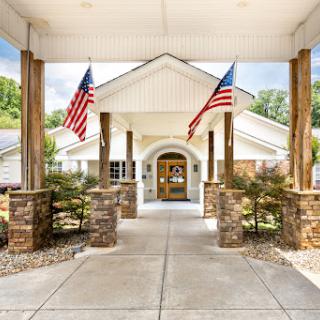 A welcoming entrance featuring American flags and beautiful landscaping.