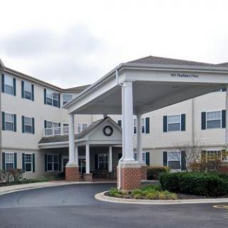 A residential building with an entrance featuring large columns and a circular driveway.
