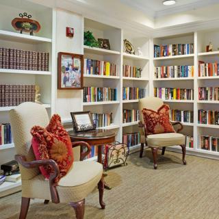A cozy reading area with bookshelves and comfortable chairs.