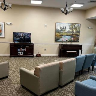 A cozy living room setup with arranged seating, a television, and a piano.