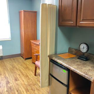 A kitchenette area featuring wooden furniture and modern amenities.