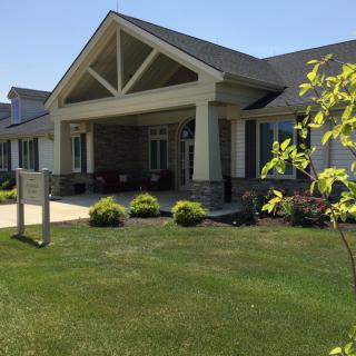 A well-maintained building entrance with a landscaped lawn.
