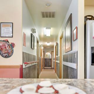 A cozy hallway view from a kitchen area, adorned with framed artwork and inviting lighting.