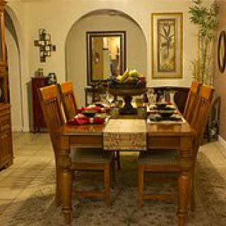 A warmly decorated dining room with a set table and wooden furniture.