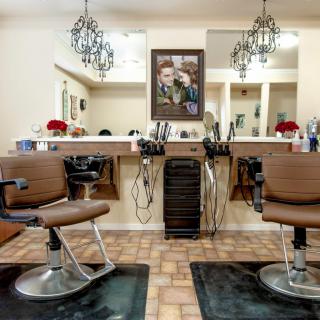 A cozy barbershop interior with chairs and mirrors lined up for customers.