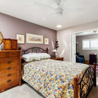A cozy and inviting bedroom featuring a colorful quilt, wooden furniture, and soft lighting.