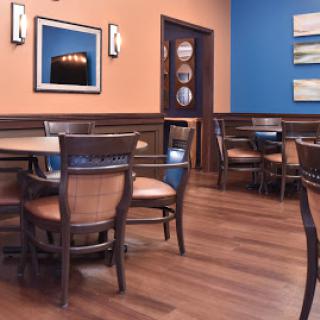 A cozy restaurant interior featuring wooden furniture, warm-colored walls, and tasteful decor.