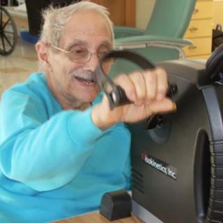 An elderly person engaging in exercise using an indoor fitness machine.
