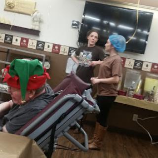 A lighthearted moment in a restaurant, featuring two people in playful costumes and a child wearing a festive hat.