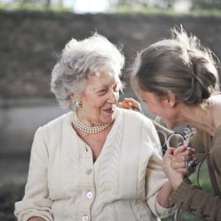 A joyful moment shared between two women, filled with laughter and warmth in an outdoor setting.