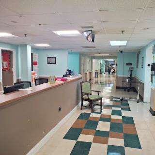 A view of a hospital reception area showcasing the waiting space and the front desk.