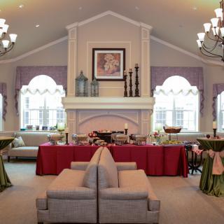 A spacious living room with elegant decor, featuring a central fireplace and arranged for a gathering.
