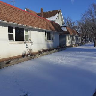 A serene winter scene showcasing houses covered in a blanket of snow under a clear blue sky.