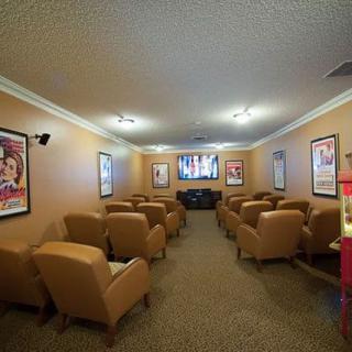 A cozy home theater with comfortable seating and movie posters on the walls.