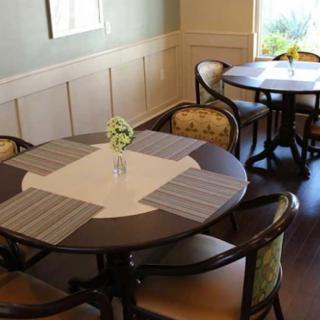 A cozy dining room with round tables, chairs, and neutral decor.