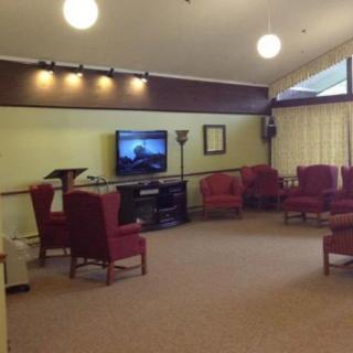 A cozy living room with several chairs arranged around a television.