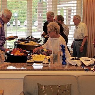 A group of people enjoy a buffet-style meal indoors.