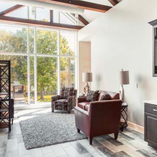 A modern living room with large windows, natural light, and stylish furniture.
