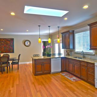 A spacious kitchen with wooden cabinets and a connected dining area.