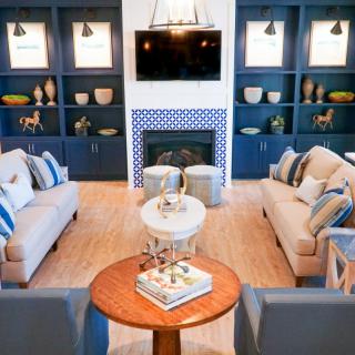 A modern living room with blue accents, featuring a cozy fireplace and stylish shelving.