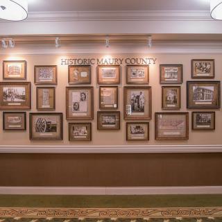 A hallway wall adorned with a collection of framed historical photographs.