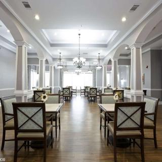 An elegantly designed dining room with chandeliers and neatly arranged tables and chairs.