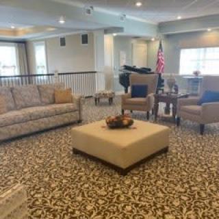 A cozy living room with sofas and chairs arranged around a central coffee table.