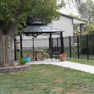 A peaceful backyard featuring a gazebo, surrounded by a fence and lush greenery.
