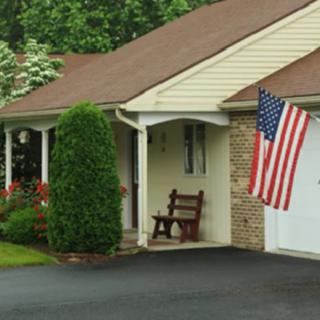 A suburban house with an American flag displayed on the front porch.