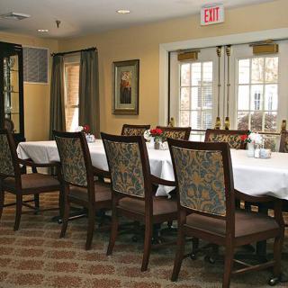 A formal dining room setup with a long table and chairs, ready for guests.