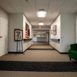 A modern hallway in an art gallery with paintings displayed along the walls.