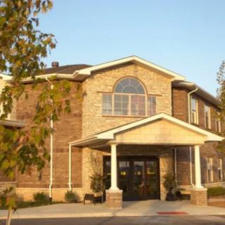 A brick building with an arched window and a covered entrance.