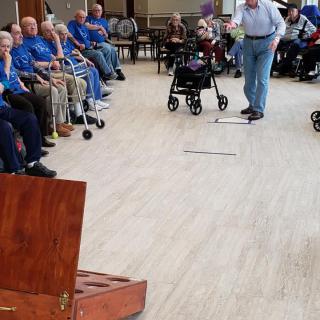 A group of seniors participating in an indoor recreational activity.