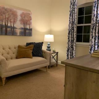 A cozy living room with a sofa, soft lighting, and elegant decor.
