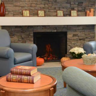 A cozy living room with armchairs and a fireplace.