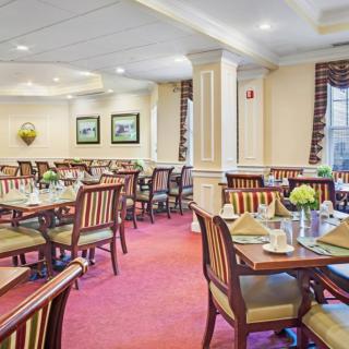 A formal dining room with neatly arranged tables and chairs.