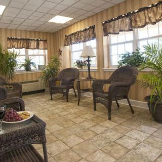 A cozy waiting room with wicker furniture and indoor plants.