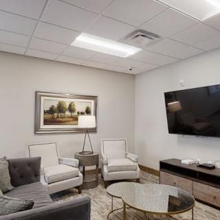A modern living room with comfortable seating and a large TV.