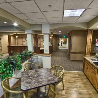 A spacious office reception area with seating, plants, and a hallway leading to other rooms.