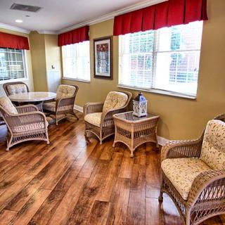 A cozy room with wicker furniture and large windows letting in natural light.