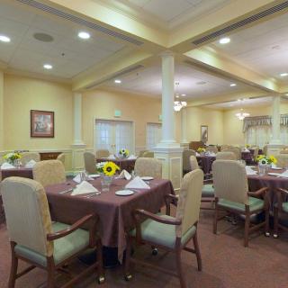 An elegantly decorated dining room with neatly arranged tables and sunflower centerpieces.
