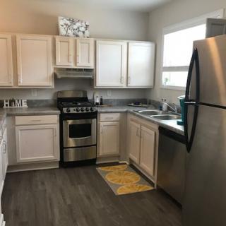 A modern kitchen with white cabinets and stainless steel appliances.